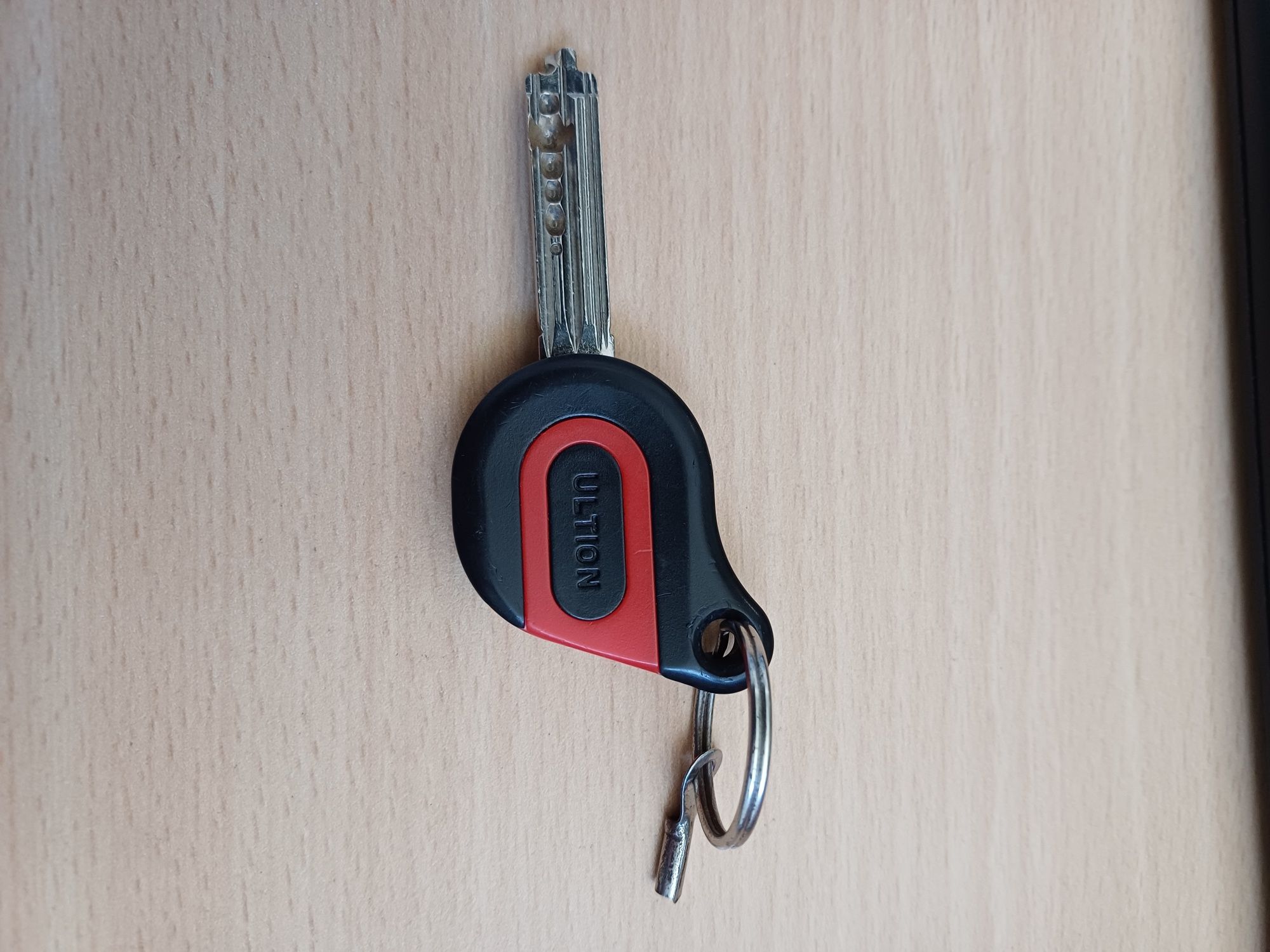 Image shows a key with the word Ultion on the bow, which is red and black