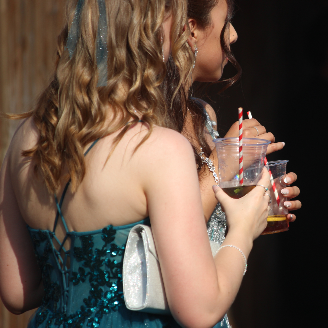 Pupils holding drinks in clear cups with striped paper straws.