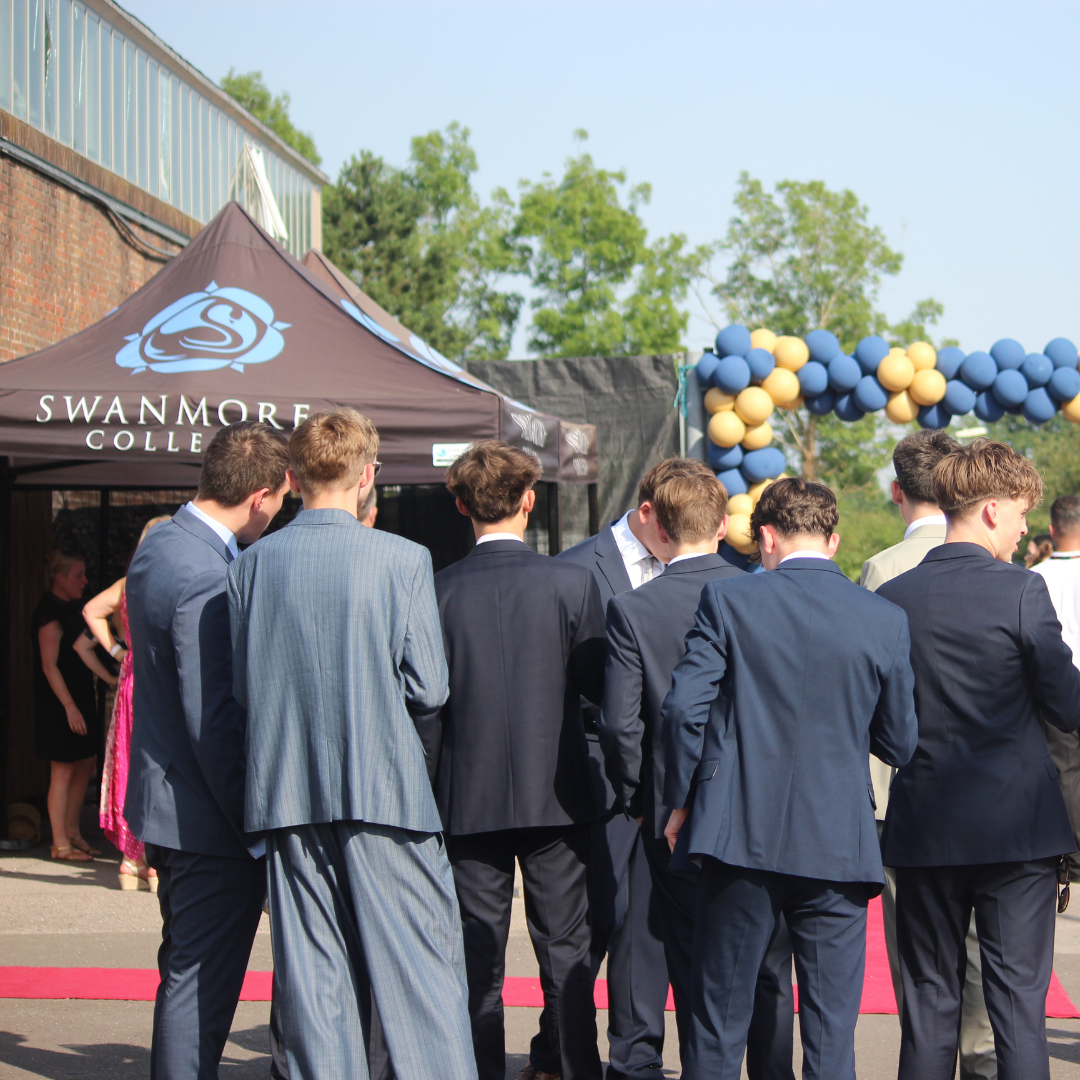 Group of pupils in formal suits gathered near the Swanmore College prom entrance.