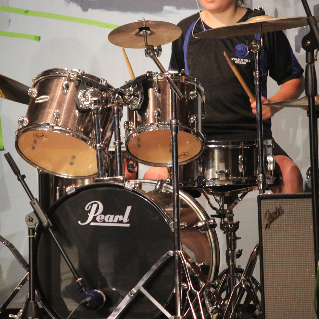 image shows a pupil in PE kit playing the drums