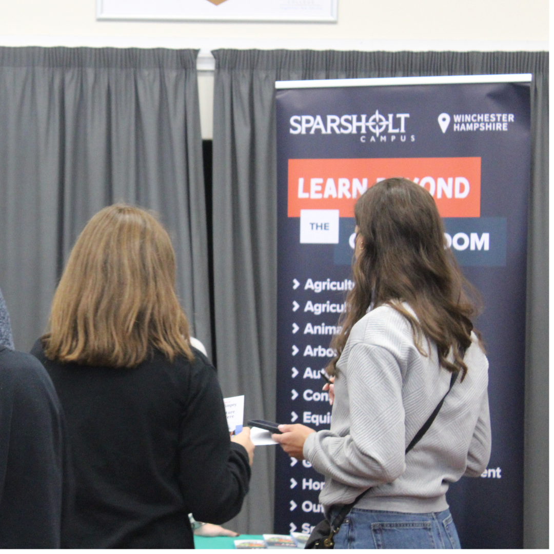 Pupils gathered at the Sparsholt College Winchester Hampshire display stand during a careers event.