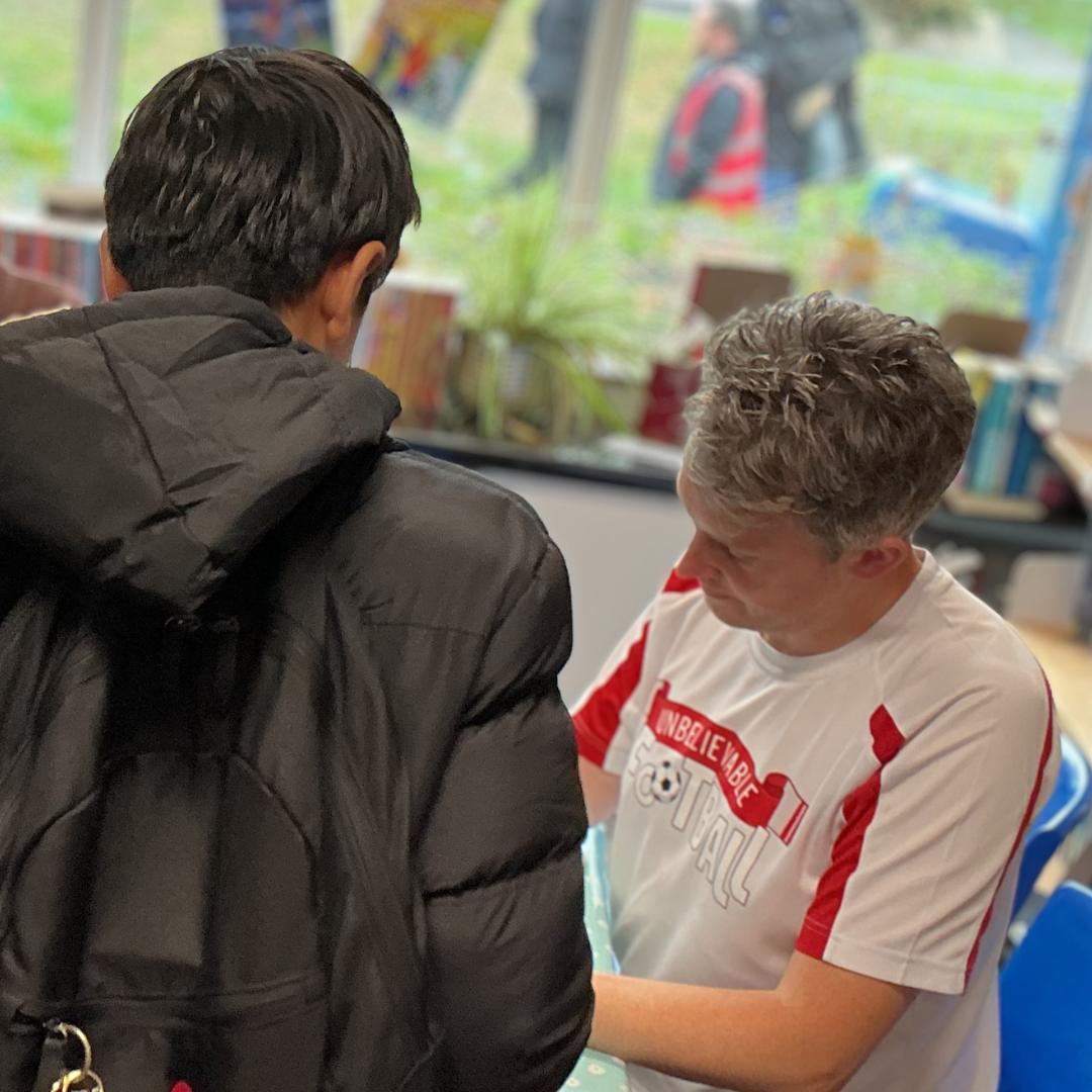 Author Matt Oldfield signing a book for a pupil during his school visit.