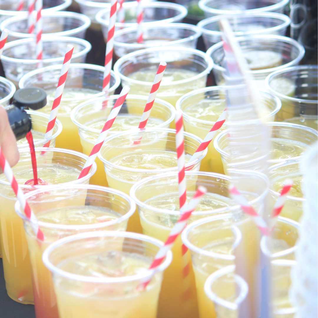 Clear plastic cups filled with drinks and red-and-white striped paper straws.