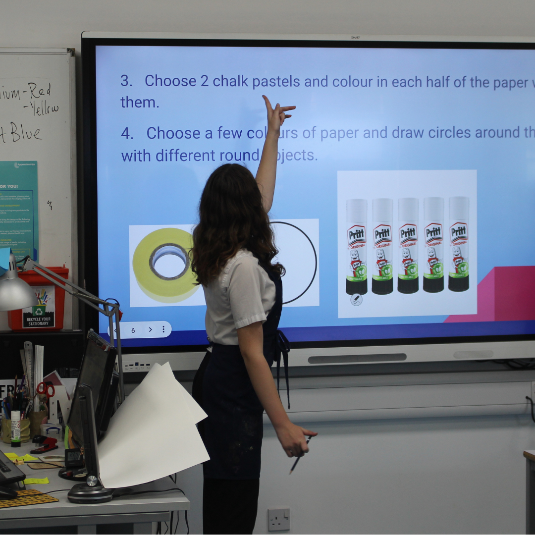 Image shows a pupil delivering a presentation on art that's shown on an interactive whiteboard.