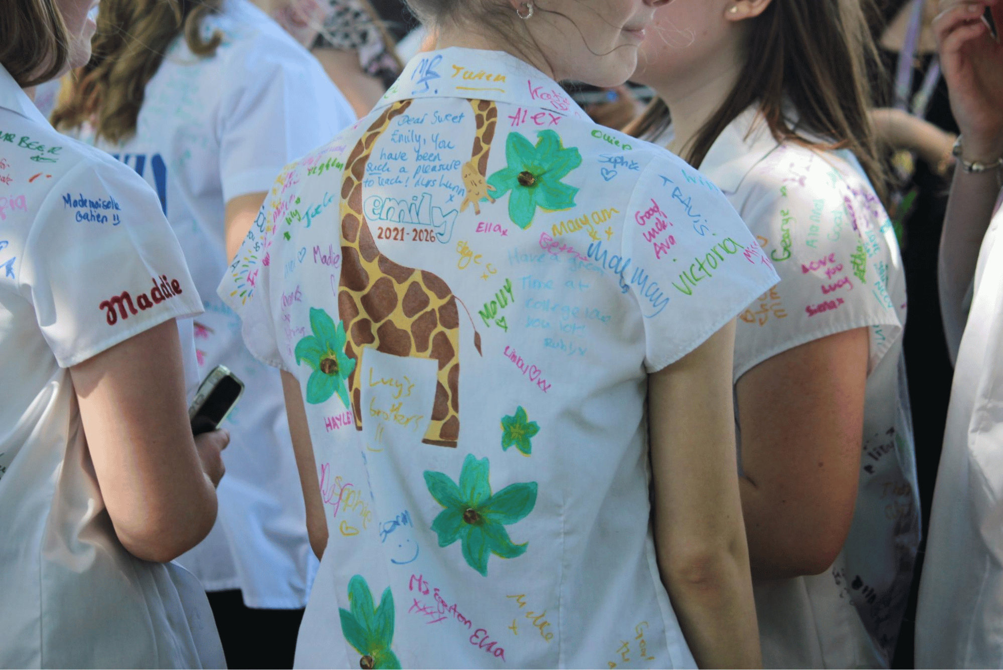 Close-up of a Year 11 pupil's shirt decorated with a hand-drawn giraffe, flowers and farewell messages.
