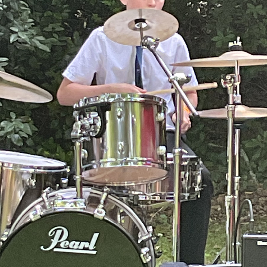 Close-up of a pupil playing the drum kit during the jazz ensemble performance.
