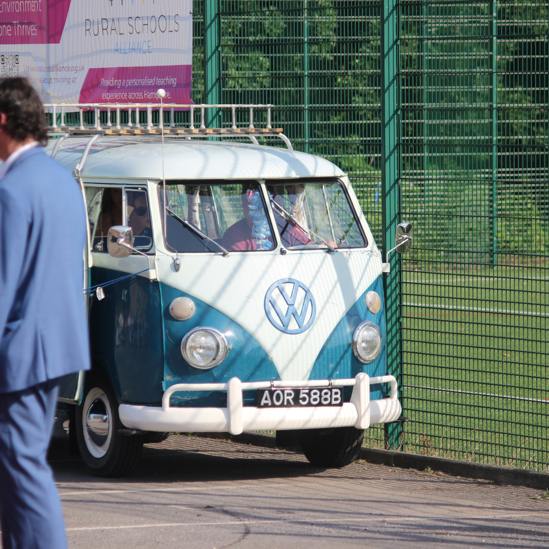 Blue and white Volkswagen camper van arriving at the prom.