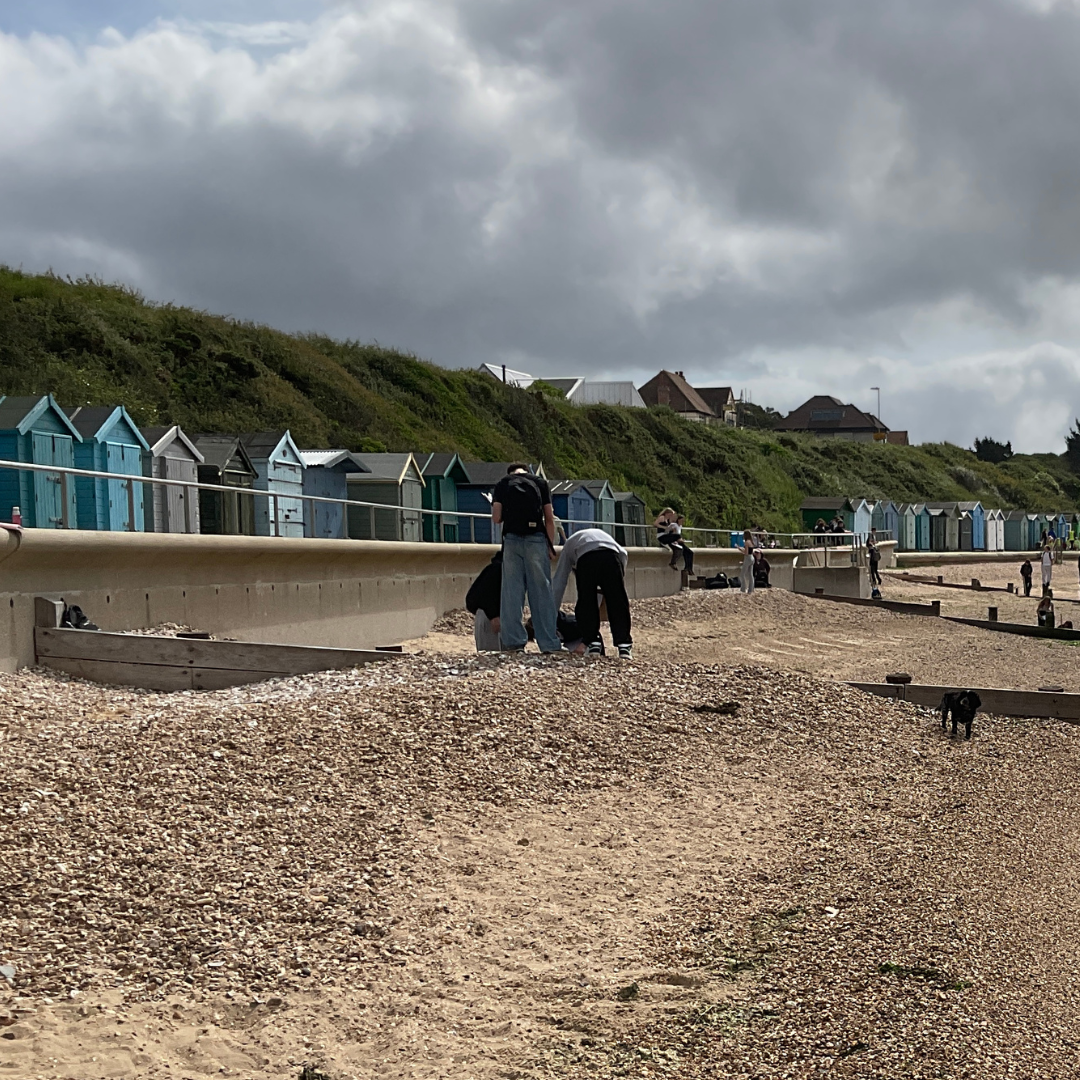Pupils carry out fieldwork on the beach near colourful beach huts at Hill Head.
