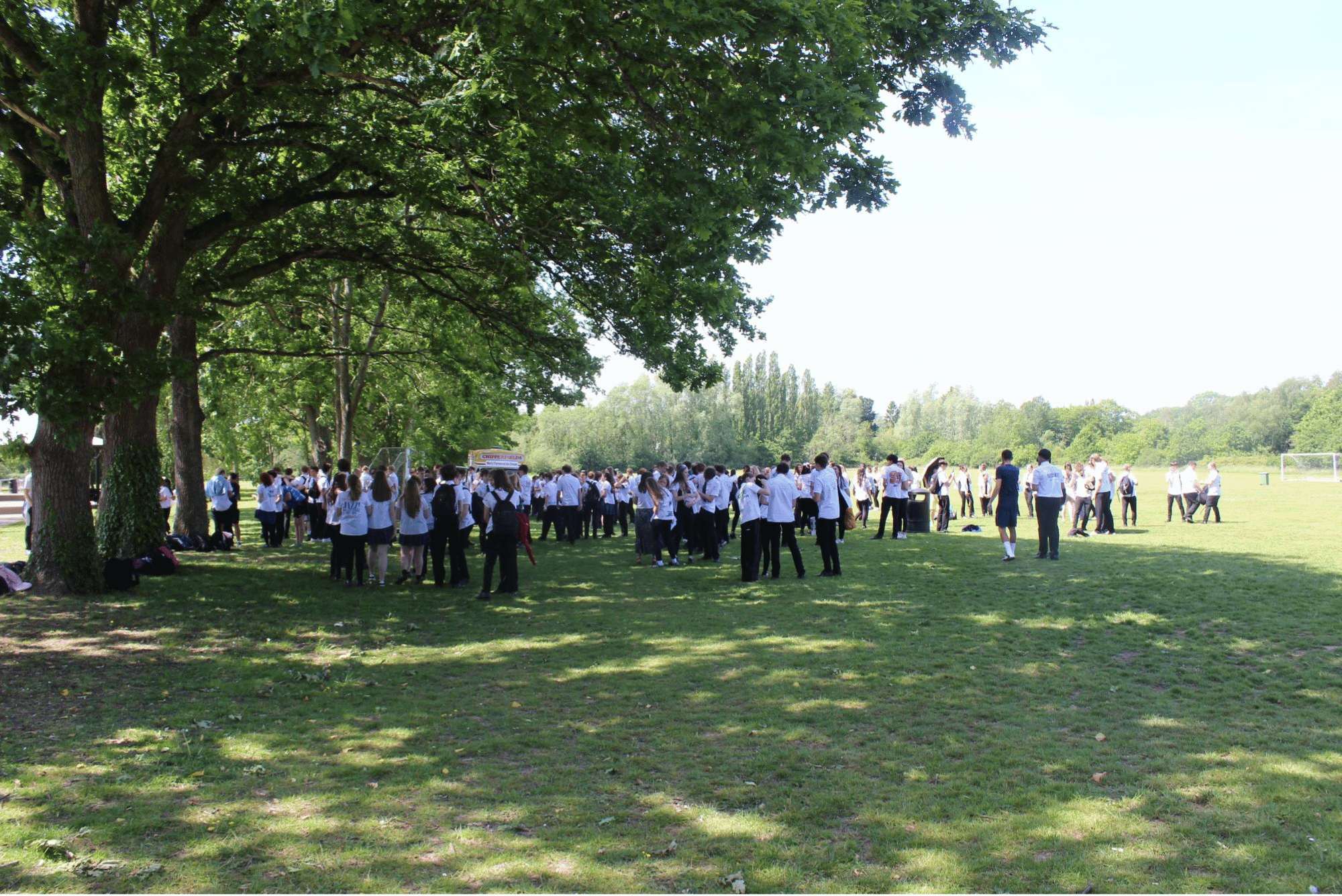 Large group of Year 11 pupils gathered on the field in signed shirts enjoying their final day at Swanmore.