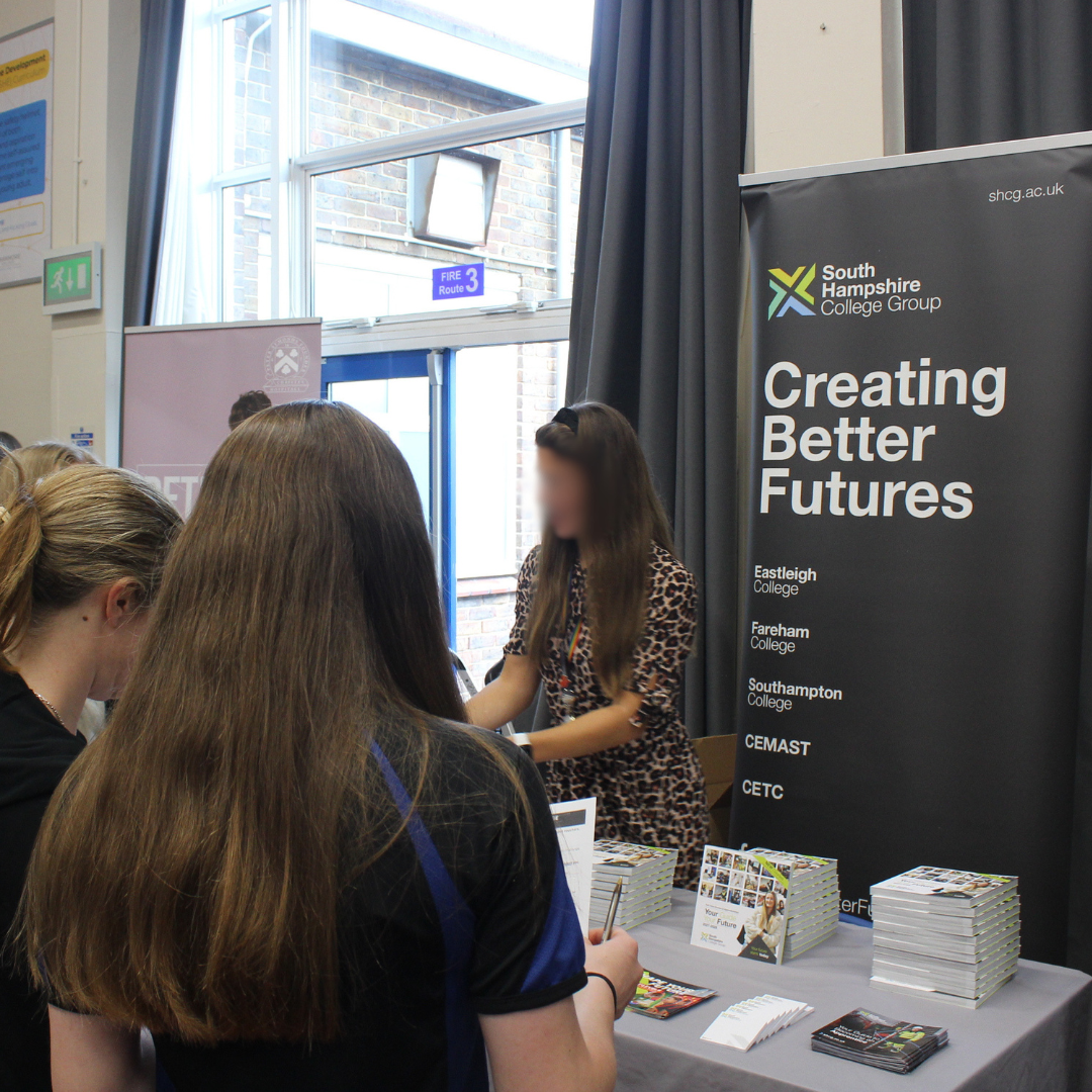 Pupils speaking with a representative at the South Hampshire College Group exhibition stand.