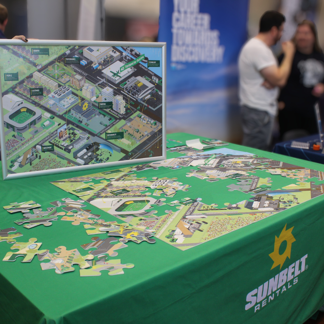 A Sunbelt Rentals exhibition table featuring an interactive site map jigsaw puzzle display.