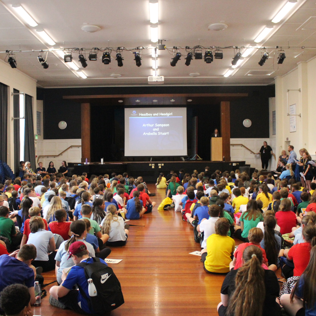 Image shows pupils sat in the Main Hall for their leaving assembly