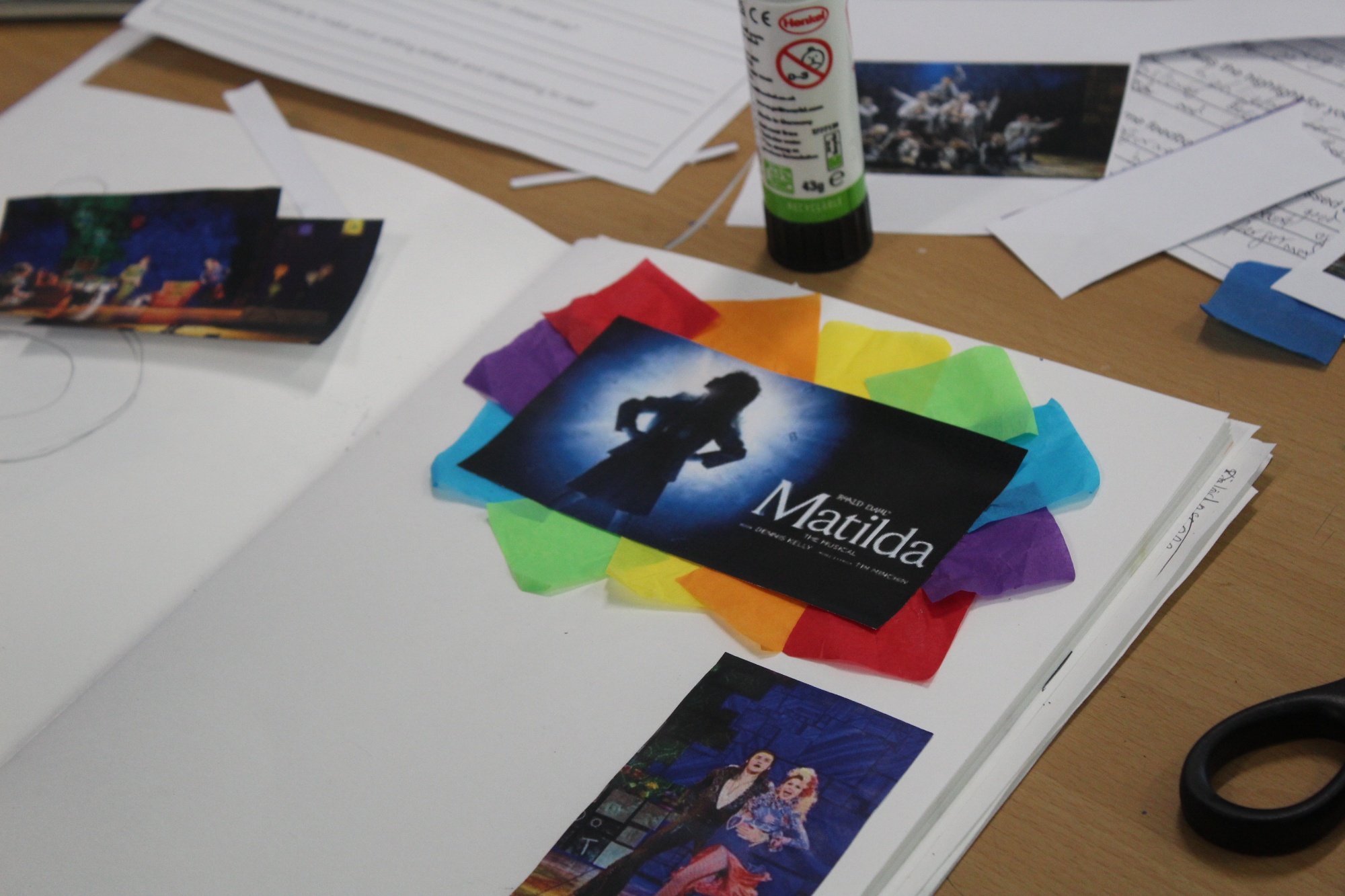 Close-up of Bronze Arts Award work featuring Matilda the Musical images, coloured paper and pupils’ creative scrapbook materials.