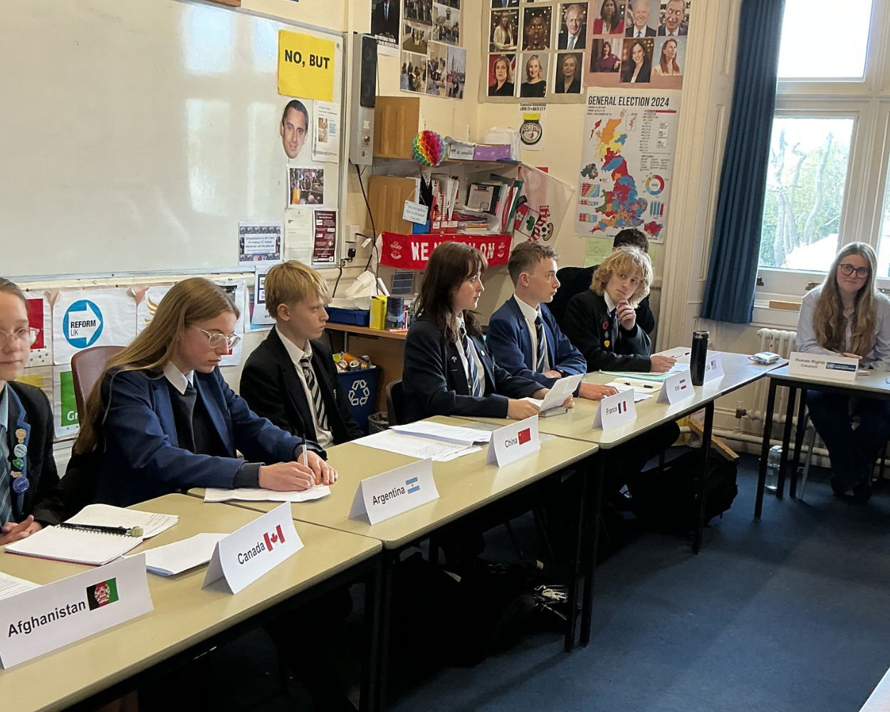 Image shows pupils sat a desk debating
