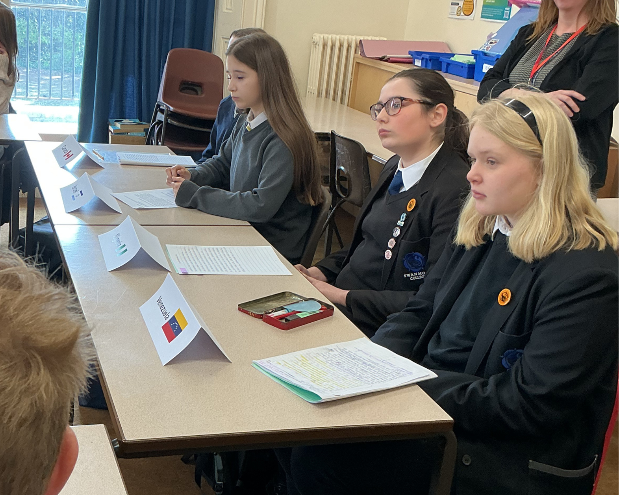 Image shows pupils listening to others speak at the Model UN