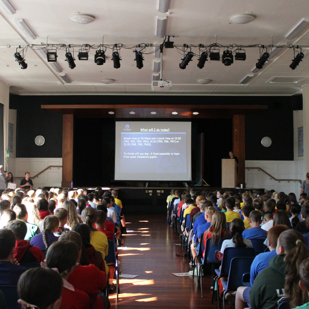 Image shows the pupils seated in the main hall for the welcome assembly