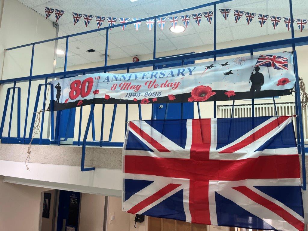Image shows the S-block landing railings decorated with a union jack, 80th Anniversary banner, and union jack bunting.