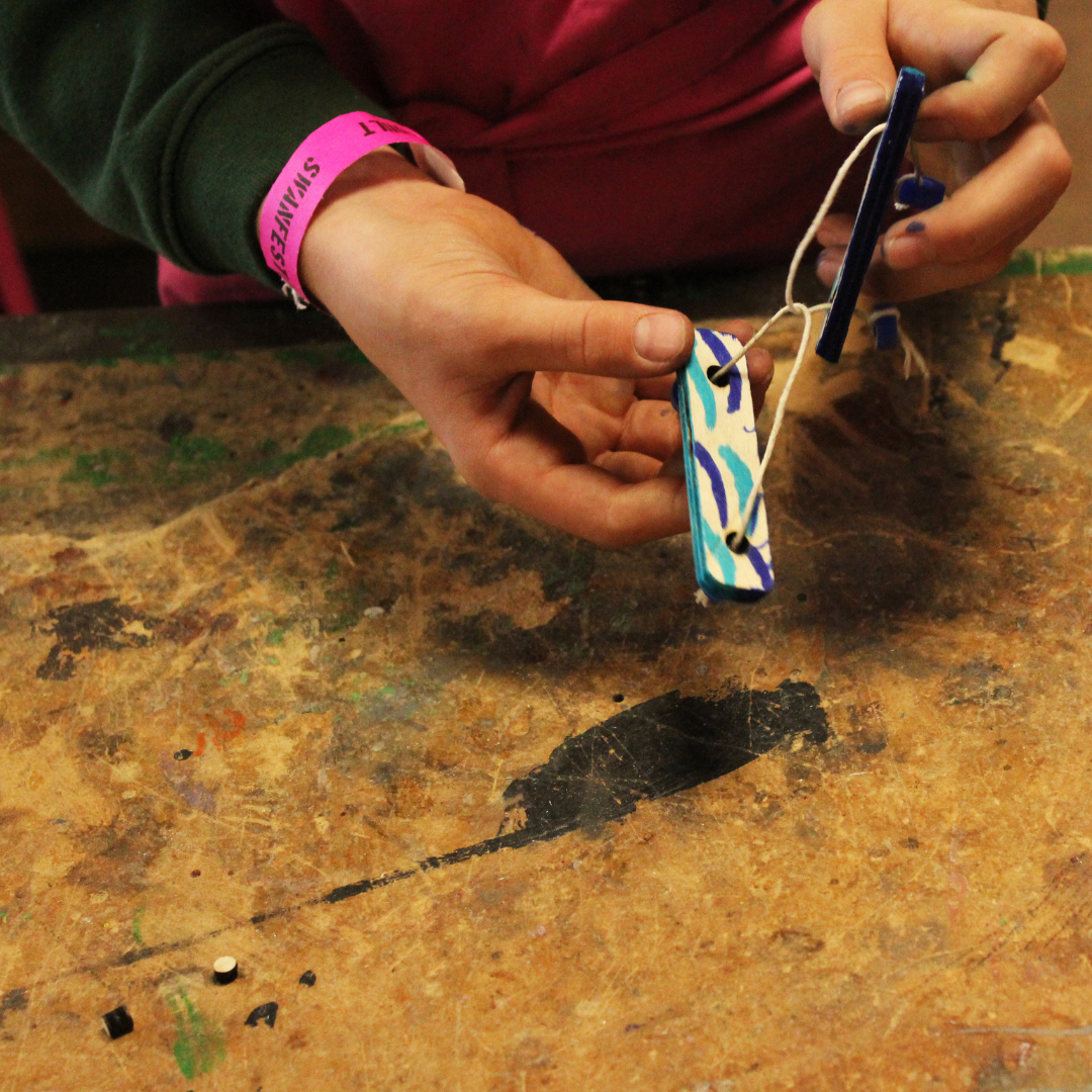 Image shows the hands of  a pupil with something they've made in technology class