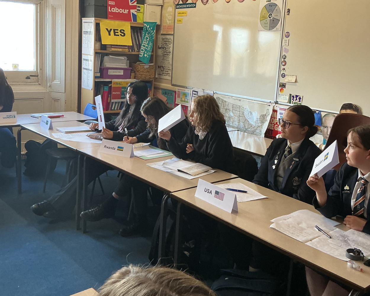 Image shows pupils voting following a debate