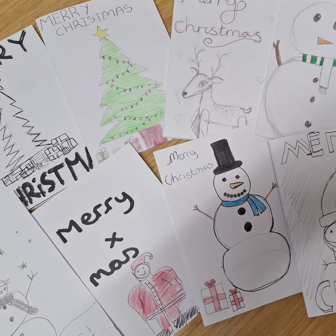 Image shows a variety of hand-made Christmas cards on a table