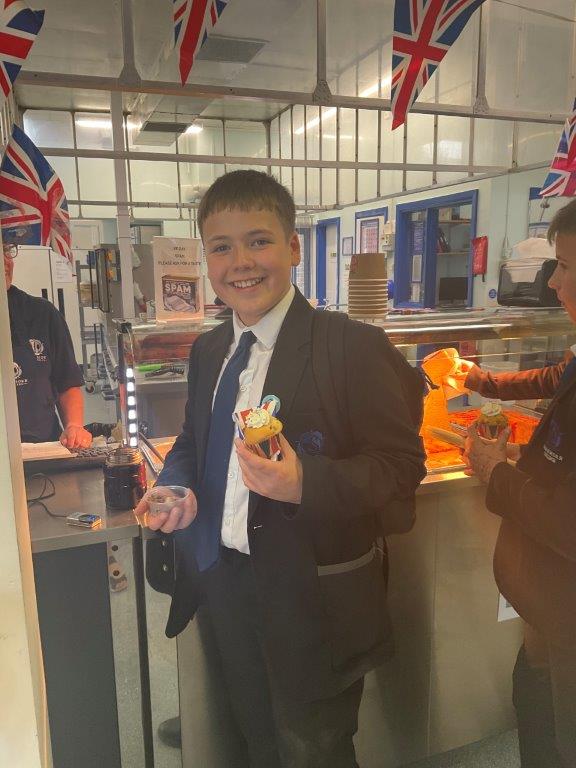 Image shows a pupil holding the cupcakes decorated for the VE Day celebrations available from the Swan Cafe.