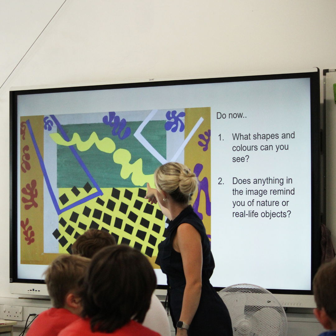 Image shows a teacher with pupils in an Art taster lesson