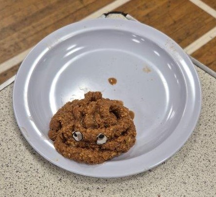 Model of digestion displayed in a white bowl, used to demonstrate how food moves through the digestive system.