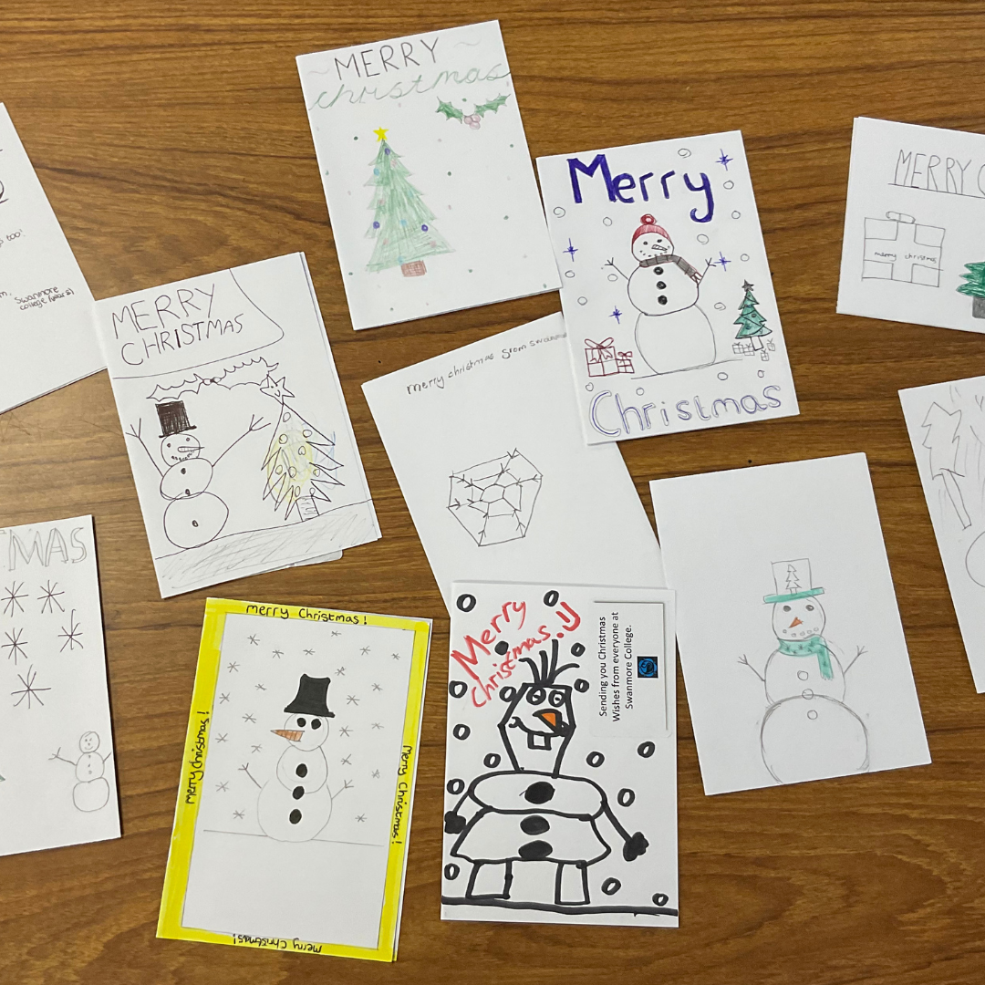 Image shows a variety of hand-made Christmas cards on a table