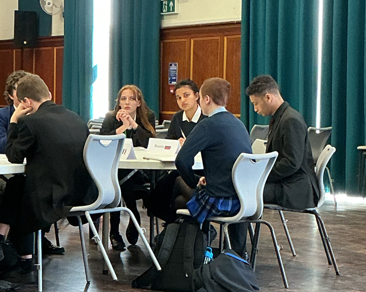 Image shows pupils debating a topic in the hall at Bay House School