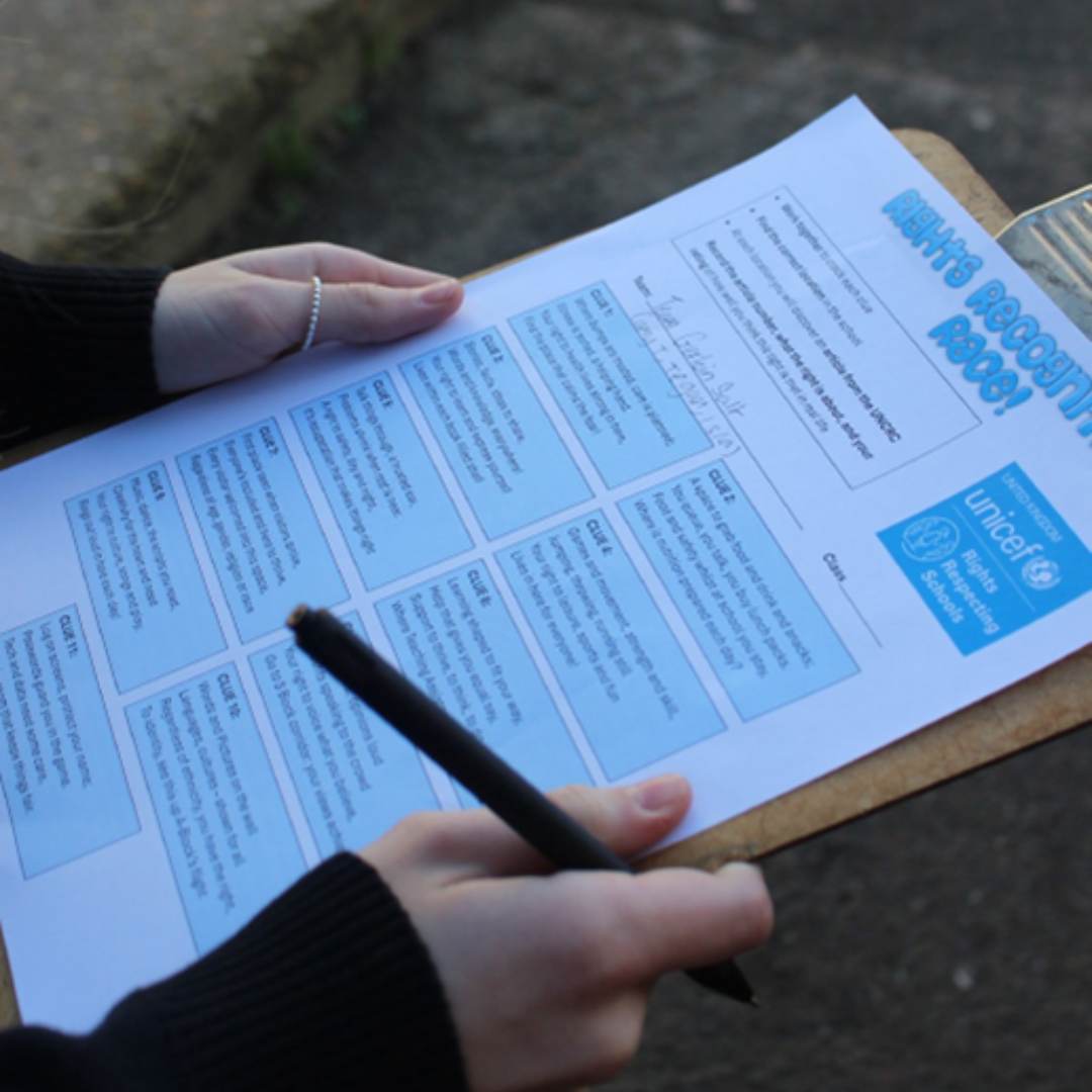 Close-up of a pupil completing a Rights Respecting Schools scavenger hunt worksheet linked to children’s rights articles.