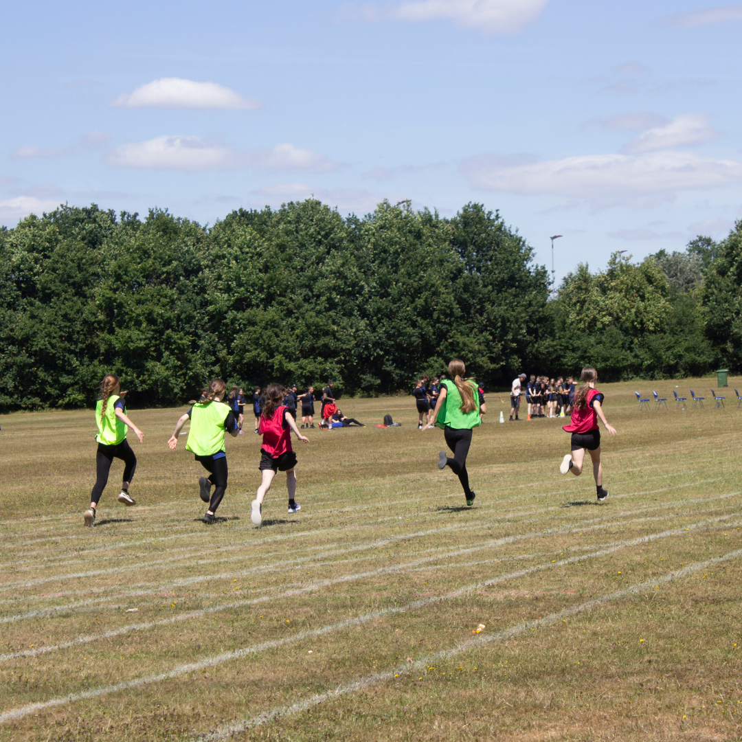 Image shows girls racing on the school field