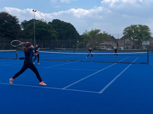 Image shows members of the Swanmore Year 9 and 10 girls' tennis team playing on the courts at King Edwards School
