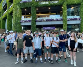 Image shows pupils at Wimbledon standing infront of the entrance to Centre Court