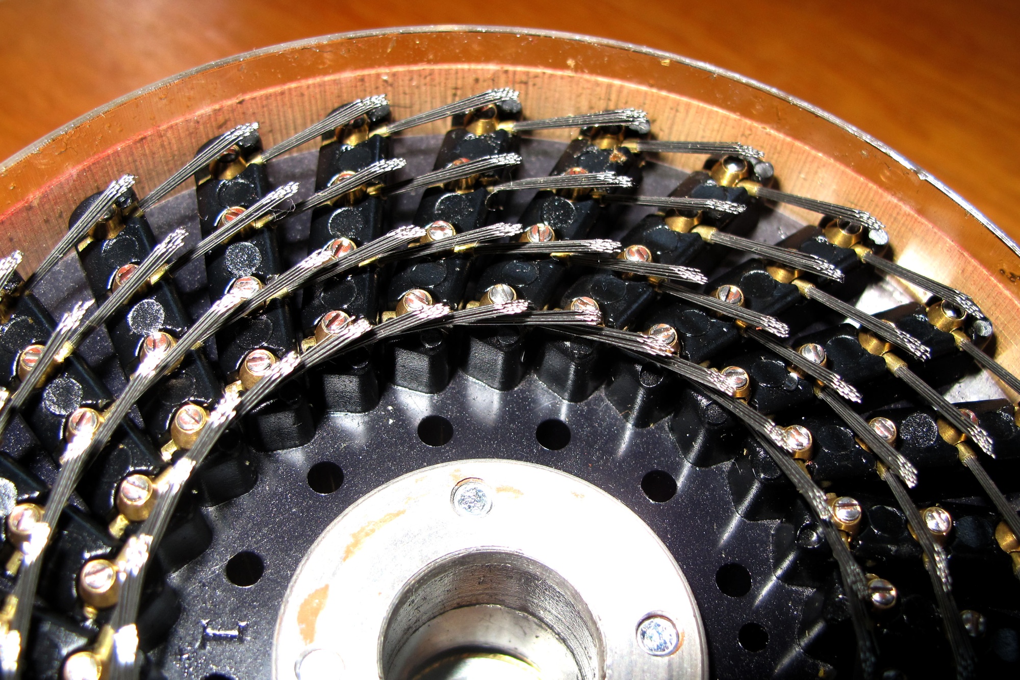 Close-up of a historic codebreaking machine with rows of wires and metal components arranged in a circular mechanism.