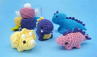Image shows amigurumi dinosaurs - amigurumi is the Japanese term that refers to crocheted or knitted stuffed animals