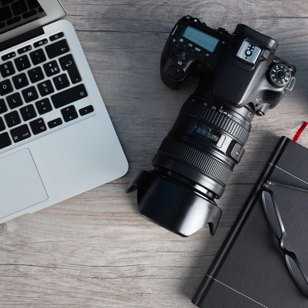 Image shows a DLR camera with a longish lens, a laptop and a notebook