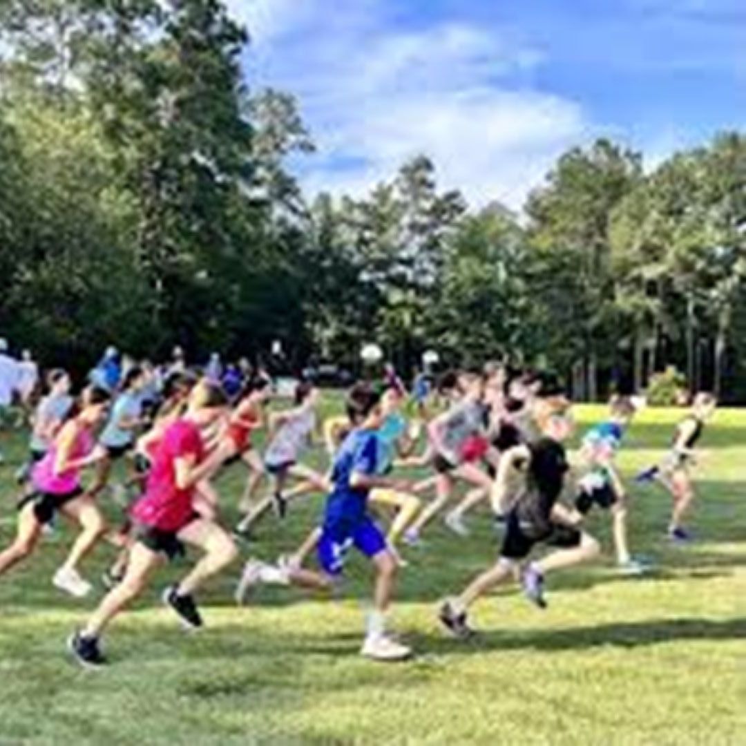 Image shows a group of children running across a field.