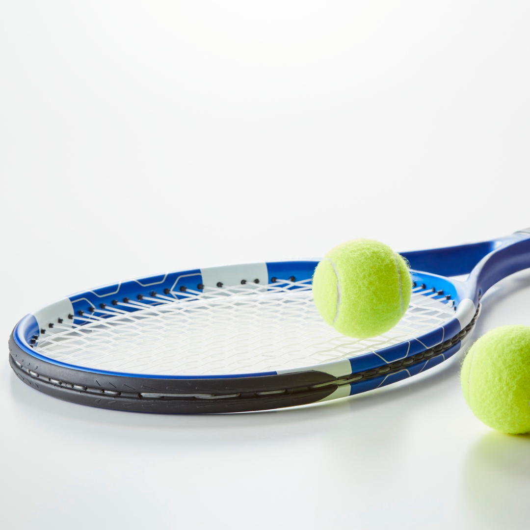 Image shows a tennis racket and two tennis balls on a white background