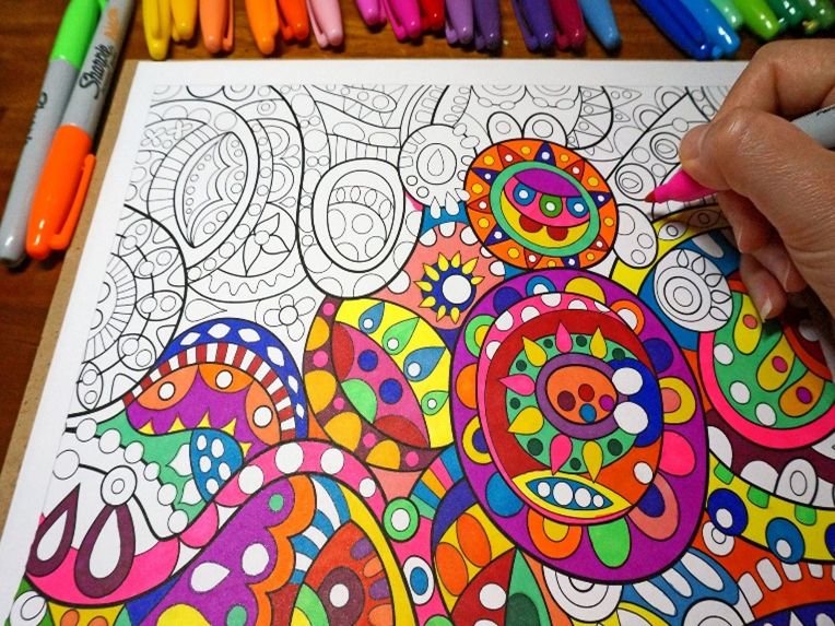 Image shows someone colouring in a complex pattern with a felt-tip pen