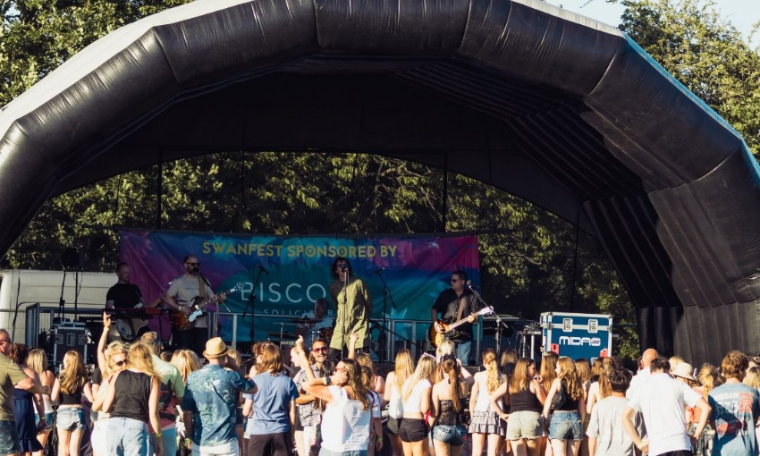 Wide shot of the main stage at SwanFest with audience gathered in front.